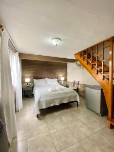 a bedroom with a large bed and a staircase at El Nono in General Alvear
