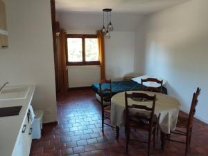 a kitchen with a table and chairs in a room at Appartement dans village calme à 5 min des lacs in Mathaux