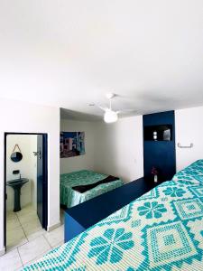 a bedroom with two beds and a mirror at Pousada Ilha de Santorini in Bertioga