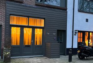 um edifício preto com cortinas cor de laranja nas janelas em BB The Warehouse Zandvoort em Zandvoort