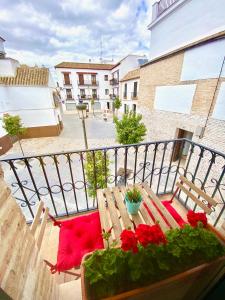 balcón con mesa de madera y almohadas rojas en Dúplex en pleno centro de Écija, en Écija