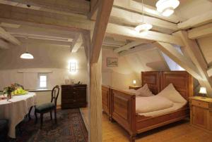 a bedroom with a bed and a table in it at Hotel Weisses Ross in Dinkelsbühl