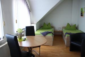 Habitación con 2 camas, mesa y sillas en Pension Domino, en Bleicherode