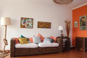 sala de estar con sofá de mimbre y almohadas coloridas en Baleal, by the sea with swimming pool, en Baleal