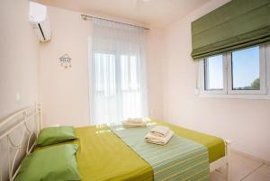een slaapkamer met een bed met handdoeken erop bij Regina Villa - Family Dream with double pool in Lachaniá