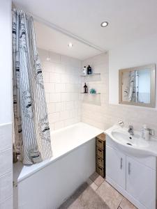 ein Badezimmer mit einer Badewanne und einem Waschbecken in der Unterkunft Cool Place 02 Academy in London