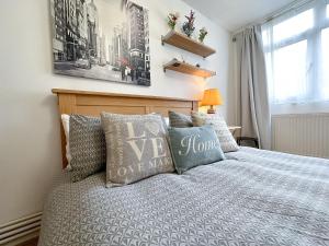 Schlafzimmer mit einem Bett mit einem Kopfteil aus Holz und Kissen in der Unterkunft Cool Place 02 Academy in London