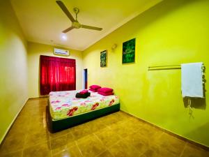 um quarto com uma cama e uma ventoinha de tecto em NABILA HOMESTAY em Pantai Cenang