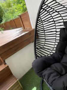 een zwarte stoel op een veranda met een terras bij Un écrin de zénitude by Lesparadis in Metz