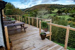 um deque de madeira com dois bancos no topo de uma casa em The Berwyn Arms em Corwen