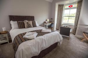 a bedroom with a large bed with towels on it at The Berwyn Arms in Corwen