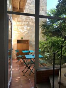 d'une terrasse avec une table, des chaises et une fenêtre. dans l'établissement Maison d'hôtes Alma, à Bordeaux