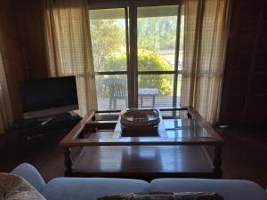 sala de estar con mesa de centro frente a una ventana en La Caleta en Tigre