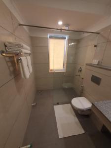 Elle comprend une petite salle de bains pourvue de toilettes et d'une fenêtre. dans l'établissement Hotel Amanthi Ladakh, à Leh
