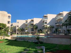 un immeuble d'appartements avec une piscine en face dans l'établissement Appartement très Haut standing vue sur mer à Mohammedia, à Mohammedia