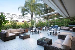 a patio with couches and tables and chairs at Courtyard by Marriott Rome Central Park in Rome