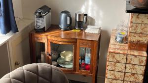 a small wooden cabinet with a blender on top of it at Onze Logeerkamer in Deil