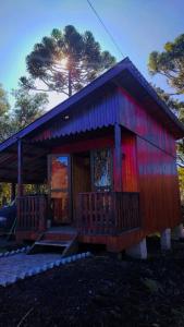 ein kleines Haus mit einem roten und blauen Dach in der Unterkunft Recosta Chalés in Cambará