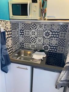 małą kuchnię ze zlewem i kuchenką mikrofalową w obiekcie Le Zen -studio tout équipé- WIFI Fibre- centre ville avec parking w mieście Tarbes