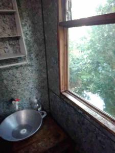 baño con lavabo y ventana en Olorin's Hut, en Copey