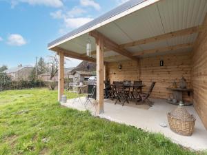 un pabellón de madera con mesa y sillas en Spacious holiday home in Doische with private pool, en Doische