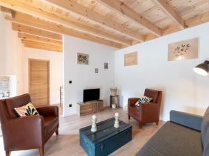 sala de estar con sofá, sillas y TV en Spacious holiday home in Doische with private pool, en Doische