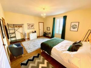 a bedroom with a bed and a chair at Le Portanel in Eymet