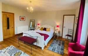 sypialnia z białym łóżkiem i różową kanapą w obiekcie Le Portanel w mieście Eymet