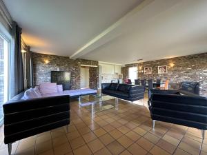 a living room with couches and a brick wall at Bungalowpark Landsrade in Gulpen