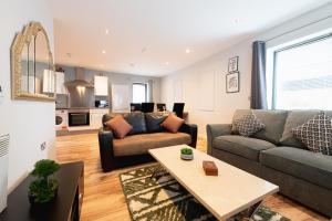 a living room with a couch and a table at Ground Floor 2 Bedroom Apartment w Parking Sleep up to 6 in L3 in Liverpool