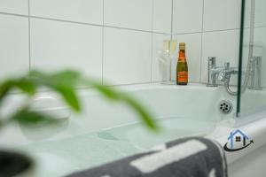 a bottle of beer sitting on a bathroom sink at Ironside House, king or twin beds, free parking, workspace, free wi-fi, corporates, pets, sleeps 8 in Thrapston