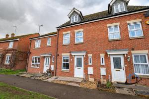 a red brick house with white doors on a street at Ironside House, king or twin beds, free parking, workspace, free wi-fi, corporates, pets, sleeps 8 in Thrapston