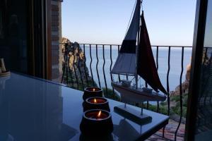 a group of candles on a balcony with the view of the ocean at Tanca Piras - Emozioni a strapiombo sul Mare!!! in Nebida