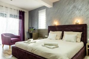 a bedroom with a large bed and a purple chair at Sunny Adriatic in Poreč +24 photos