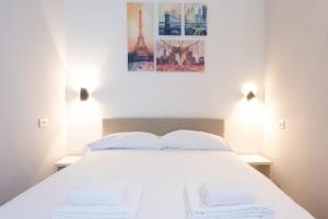 a bedroom with a white bed with two white pillows at Porta Venezia Elegant Penthouse with Terrace in Milan
