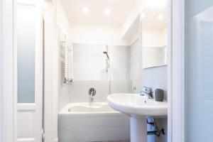 a white bathroom with a sink and a bath tub at Porta Venezia Elegant Penthouse with Terrace in Milan