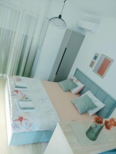 a small bedroom with a bed with a blue headboard at Apartman Iskra in Trebinje