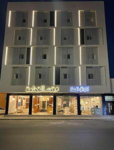 a building with a sign on the side of it at Waqet AlFakhama Furnished Apartments in Tabuk