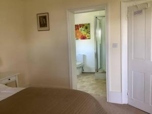 a bedroom with a bed and a bathroom with a toilet at Church house in Claines