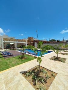 un patio con piscina y palmeras en House Aconchegante Ponta Negra en Natal