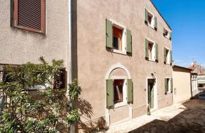 a building with green shutters on the side of it at Boutique Wrungel in Vrsar