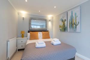 um quarto com uma cama com duas toalhas em One Harp Hill em Cheltenham
