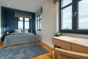 een slaapkamer met blauwe muren en een bed en ramen bij Mazurskie Wille - Willa Niebieska - siedlisko na Mazurach z bezpośrednim dostępem do jeziora Dejguny oraz prywatnym basenem in Sterławki Wielkie