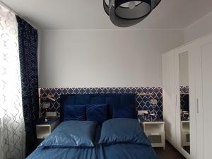 a bedroom with a blue bed with a blue headboard at Kryształowy apartament in Tarnowskie Góry