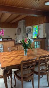 a dining room table with a vase of flowers on it at Maison de vacances 