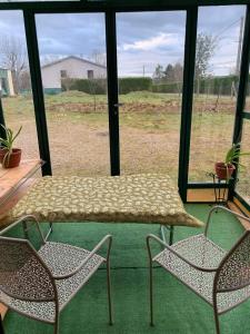 a table and two chairs in a room with a window at Maison de vacances 