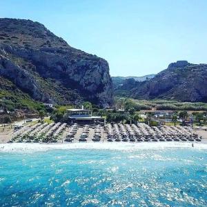 uma praia com um monte de cadeiras e a água em Katerina summerhouse em Dhaskalión