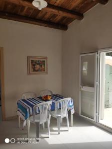 mesa de comedor con sillas y mantel azul y blanco en Casa vacanze La Meridiana, en Donnalucata