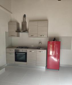 Cette chambre comprend une cuisine équipée d'un réfrigérateur rouge. dans l'établissement Casa vacanze La Meridiana, à Donnalucata