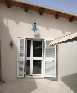 un edificio blanco con una ventana y una luz azul en Casa vacanze La Meridiana, en Donnalucata